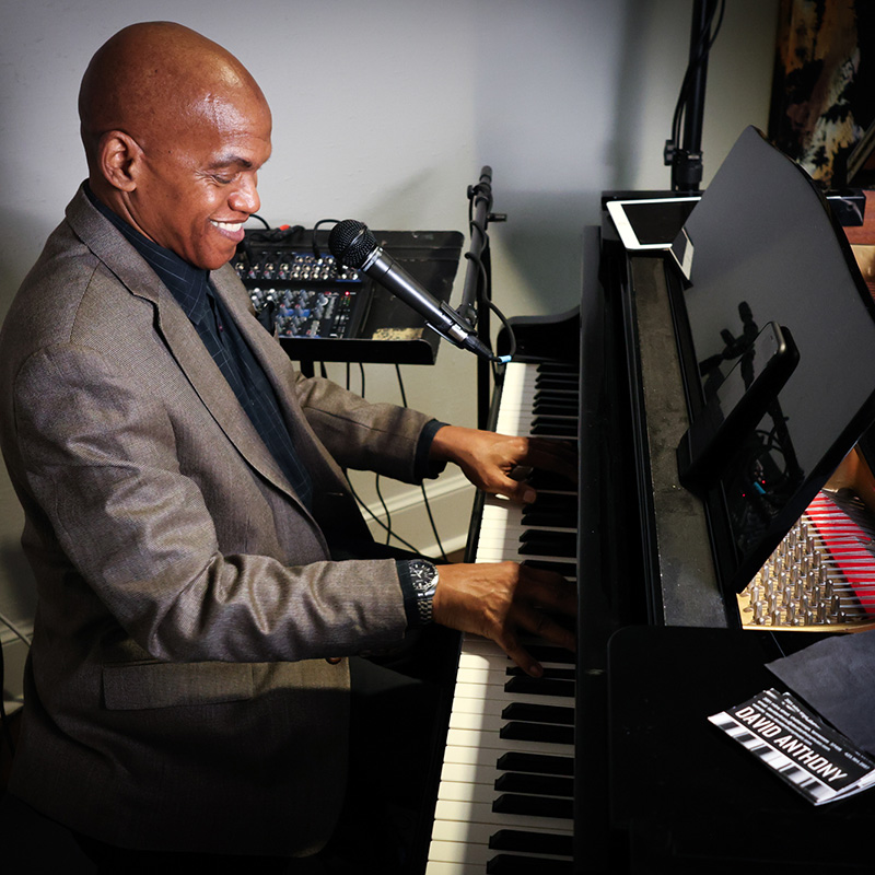 David Anthony smiles as he plays the piano just off the lobby at The Walden Club.