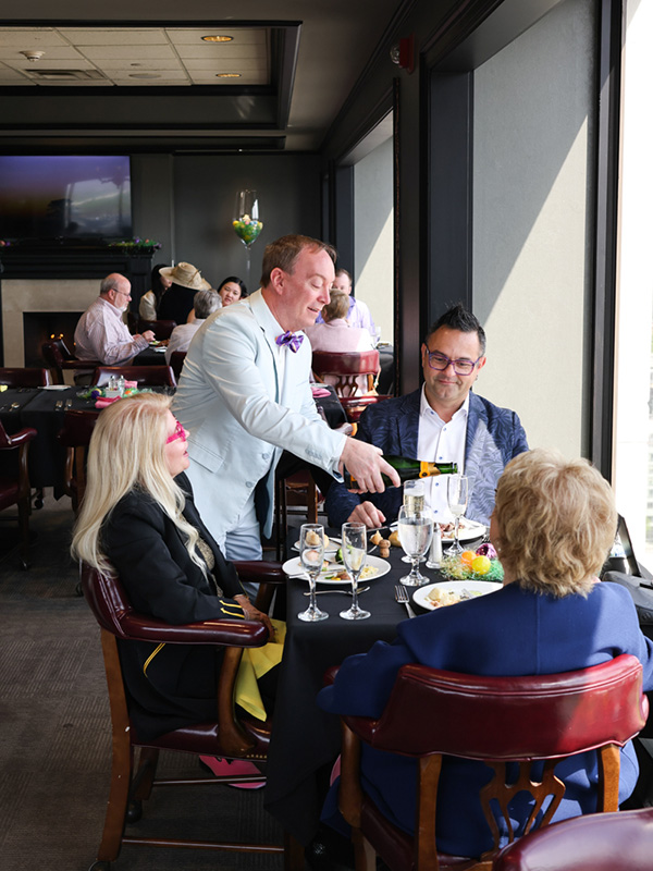 The General Manager serving Members their drinks as they enjoy a meal in the Tavern at the Walden Club.